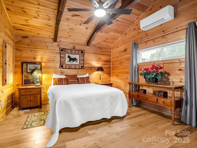 a bedroom with a bed and wooden floor