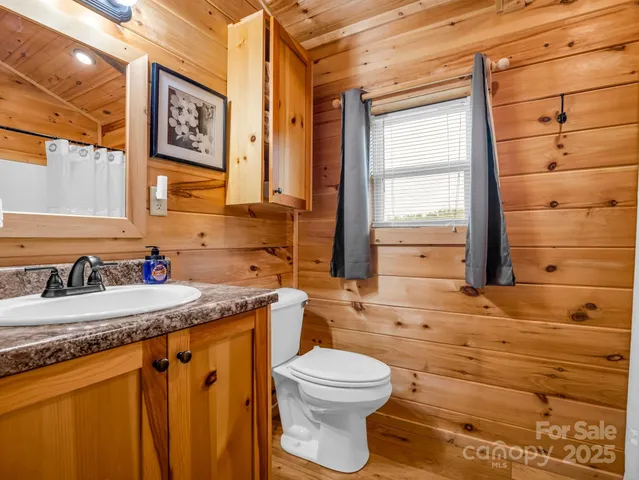 a bathroom with a granite countertop toilet sink and mirror