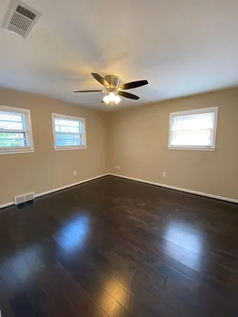 a view of wooden floor and a chandelier fan in a room