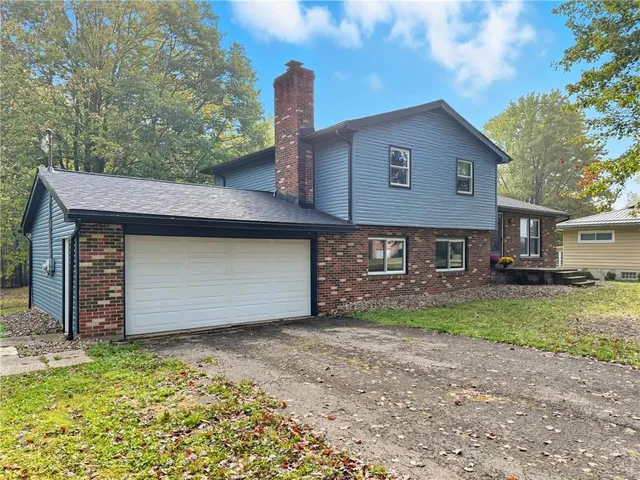 a front view of a house with a garden and yard