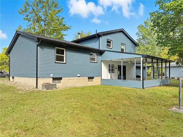a front view of house with yard and trees in the background
