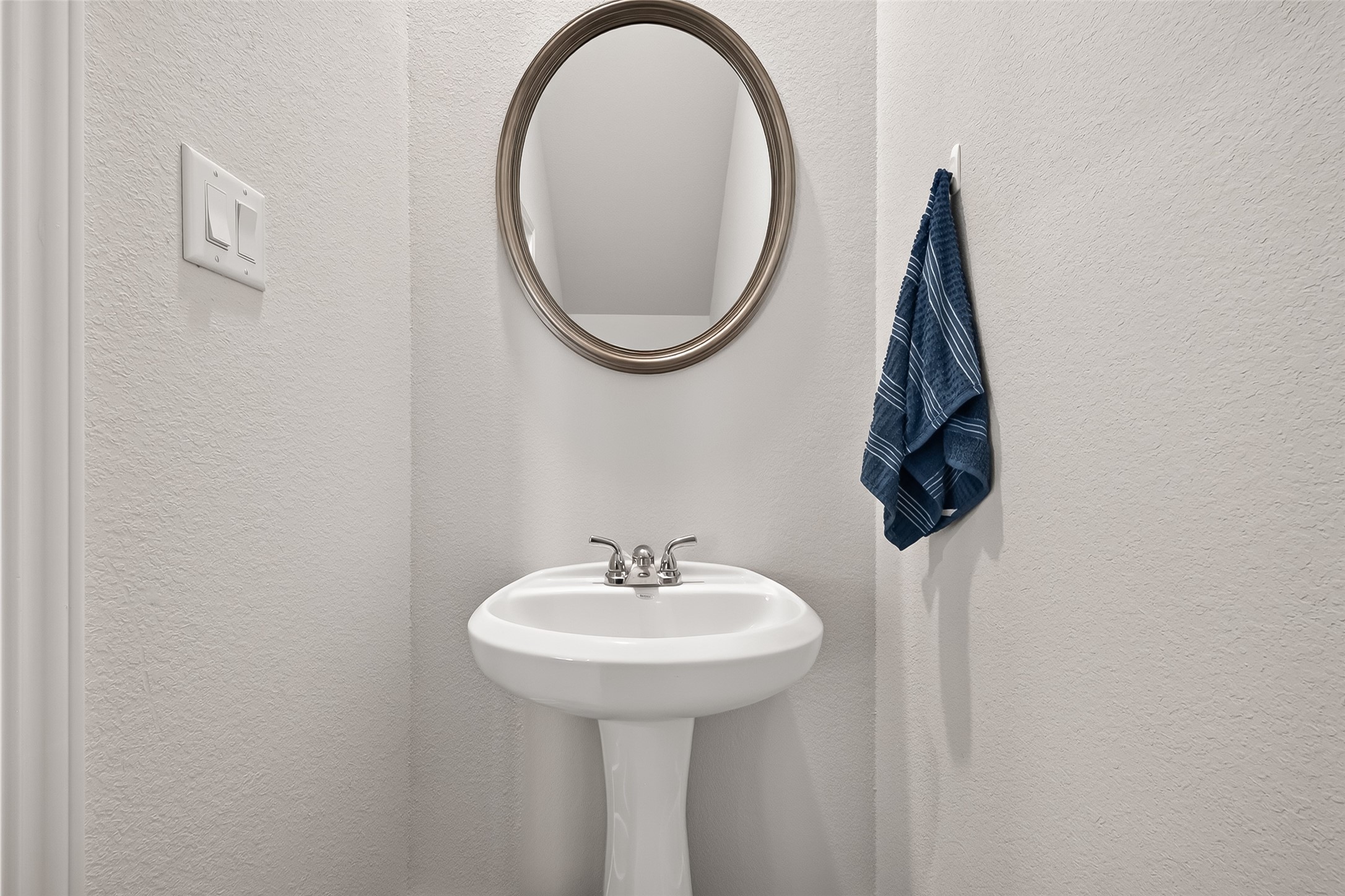 4004 Baja Lane Houston, TX 77045 - Photo 16 of 34 Sleek modern powder room. This compact half-bath features a pristine pedestal sink and a contemporary round mirror set against fresh neutral walls. A perfectly appointed space designed with your guests' comfort in mind.