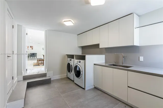 a utility room with cabinets washer and dryer