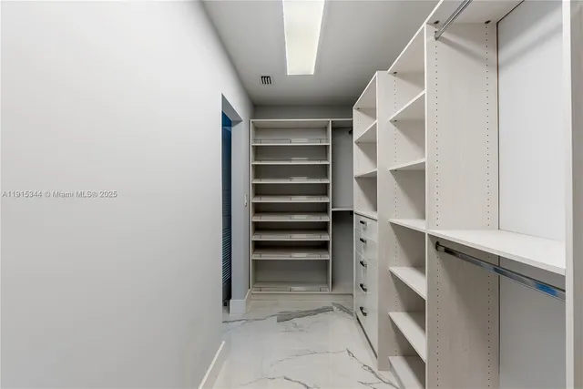 a view of walk in closet with empty racks