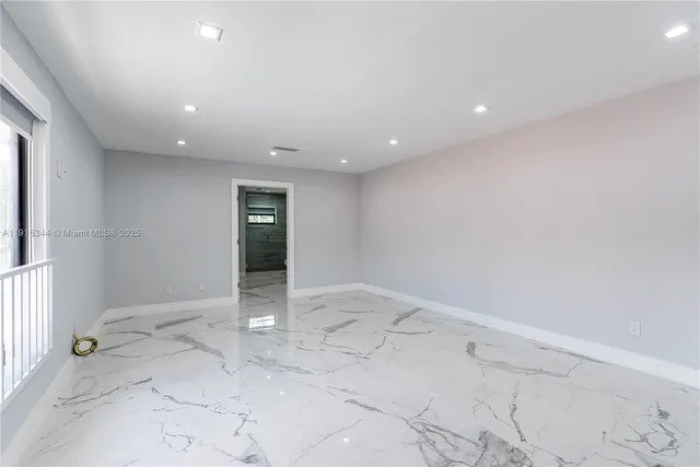 an empty room with entrance and windows