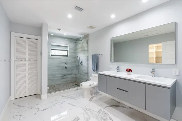 a bathroom with a double vanity sink toilet and shower