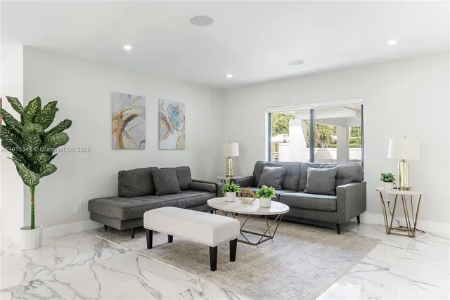 a living room with furniture potted plant and window