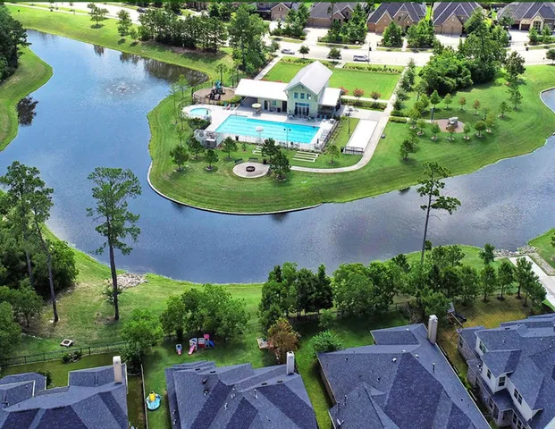 an aerial view of a house with a garden and lake view