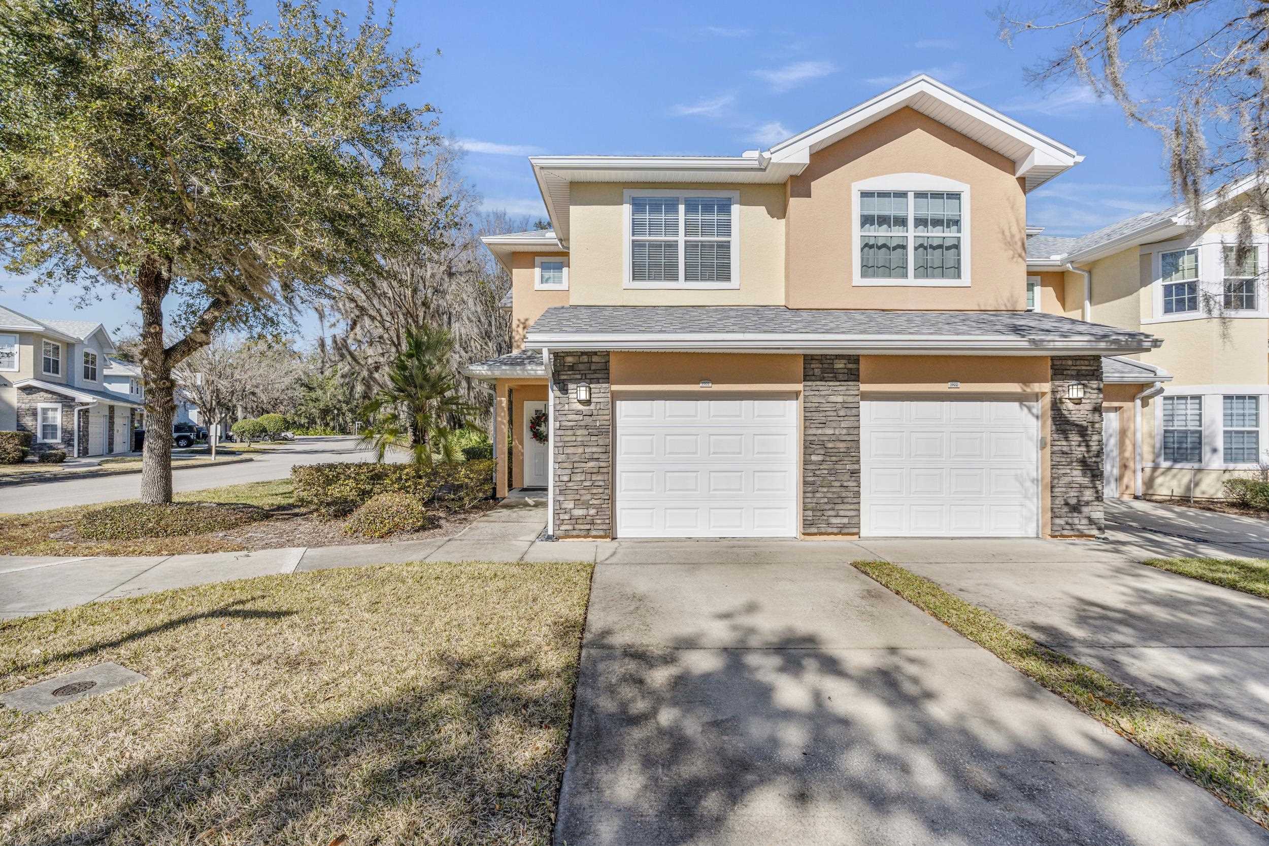 110 Magnolia Crossing Point, Unit 1901 St. Augustine, FL 32086 - Photo 2 of 38 Traditional-style home featuring an attached garage, concrete driveway, stucco siding, and stone siding
