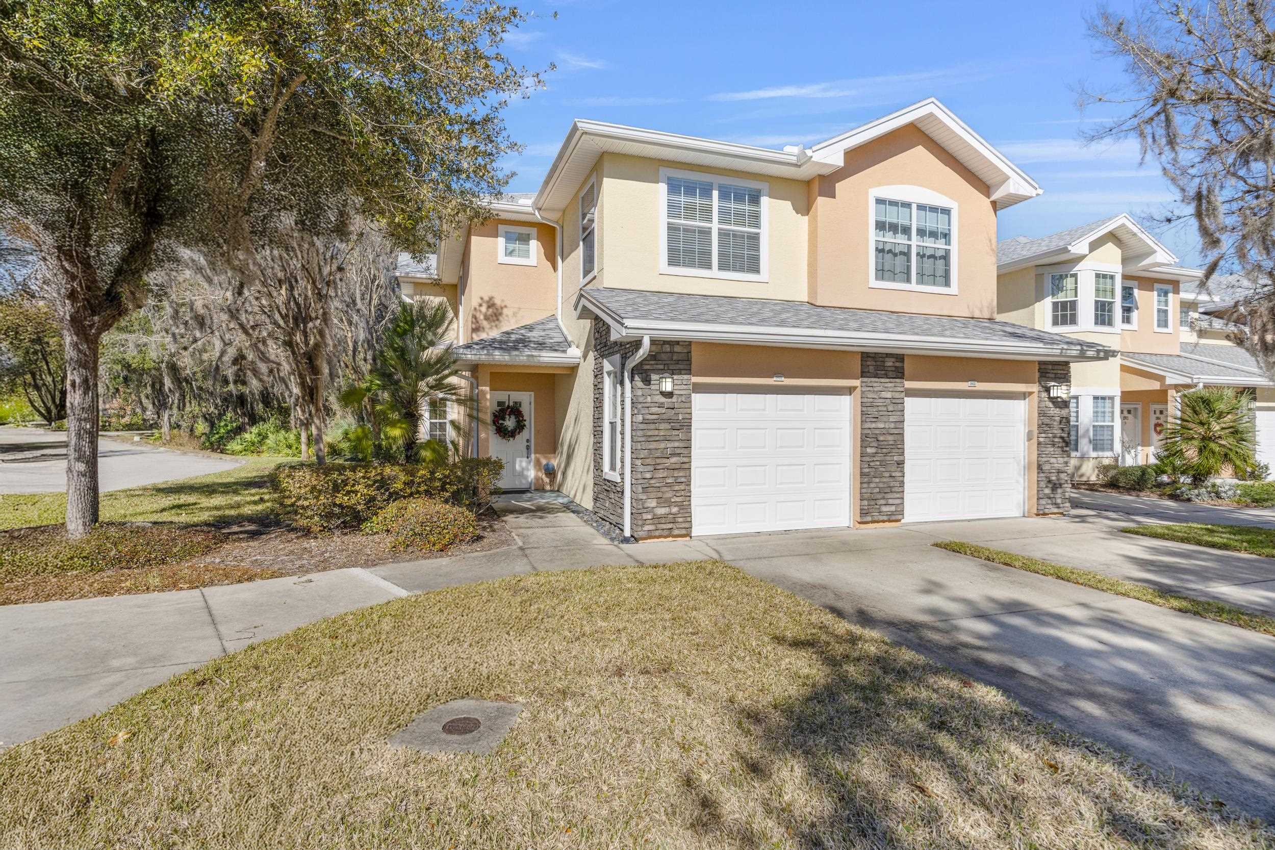 110 Magnolia Crossing Point, Unit 1901 St. Augustine, FL 32086 - Photo 3 of 38 Traditional home featuring stucco siding, a garage, driveway, stone siding, and a front lawn