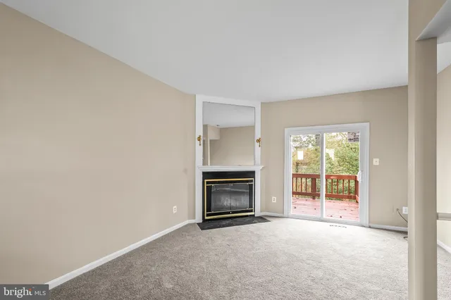 a view of an empty room with a fireplace and a window