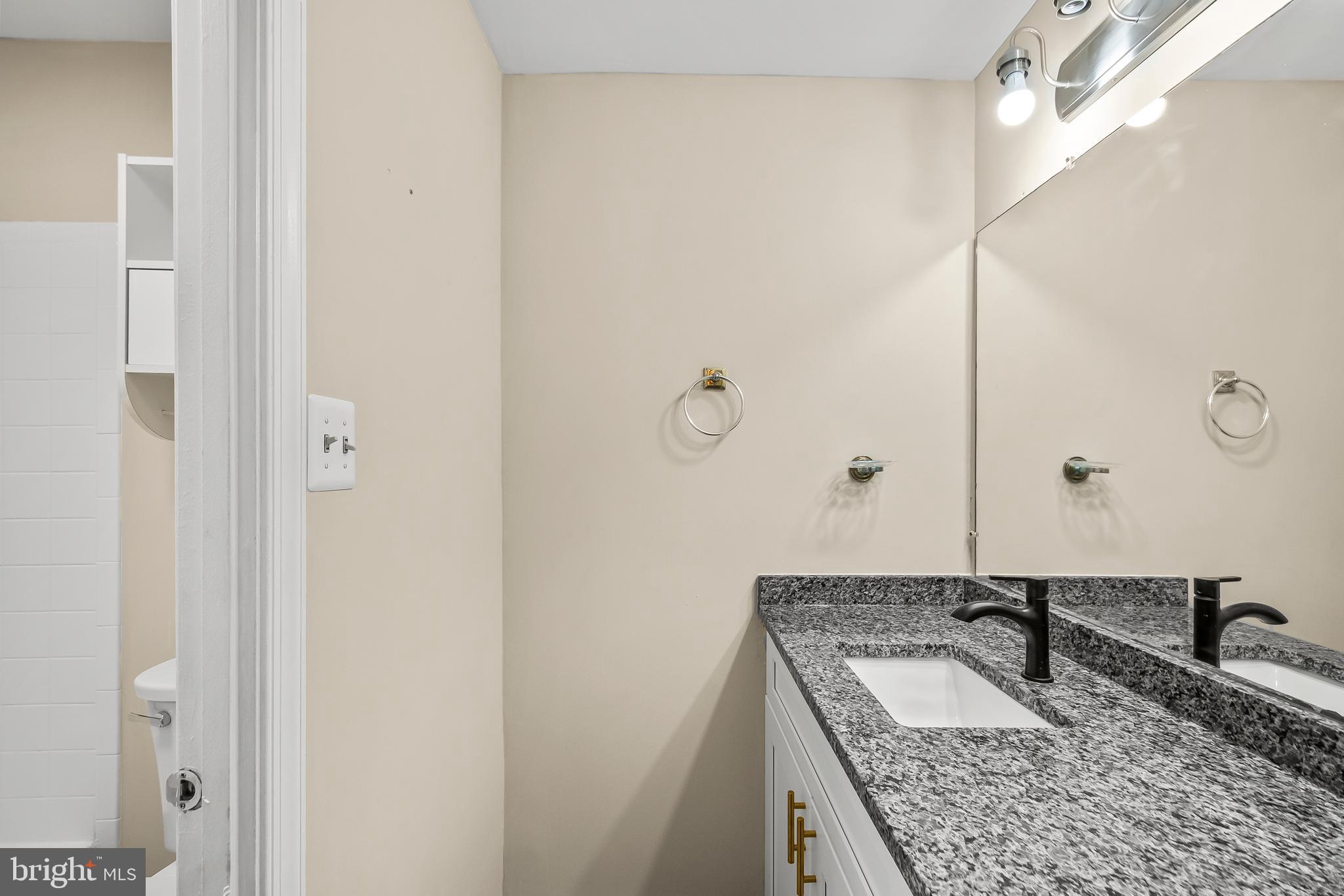 6185 Little Valley Way Alexandria, VA 22310 - Photo 23 of 44 a bathroom with a granite countertop sink and a mirror