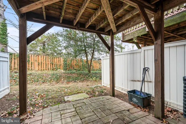 a view of a house with a tree and wooden fence