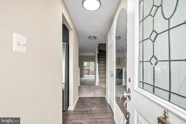 a view of a hallway with wooden floor and door with glass door