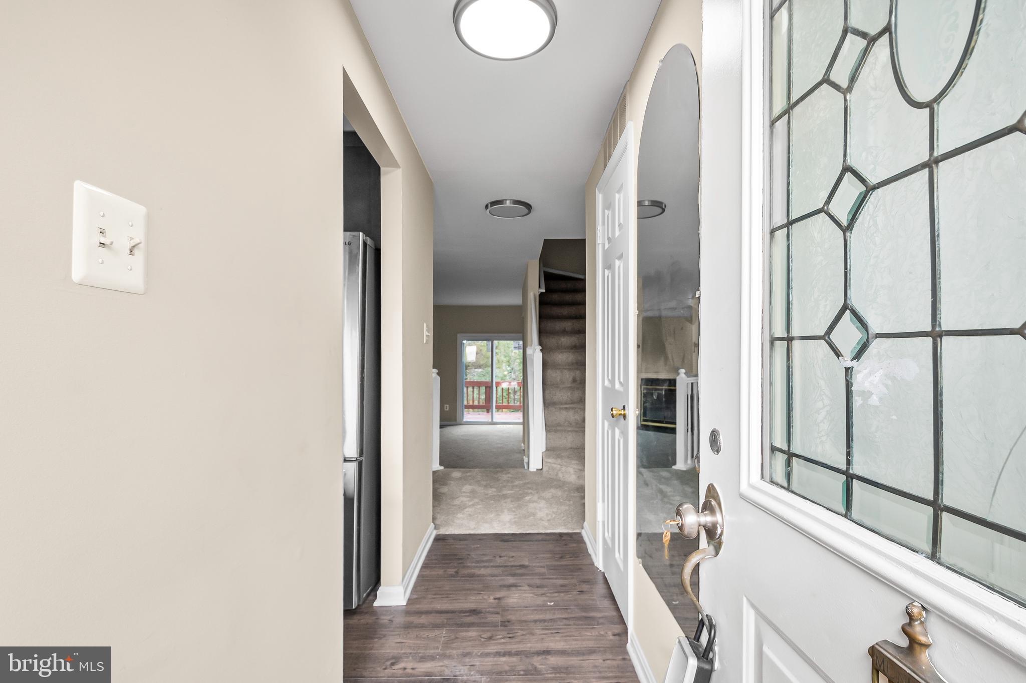 6185 Little Valley Way Alexandria, VA 22310 - Photo 5 of 44 a view of a hallway with wooden floor and door with glass door