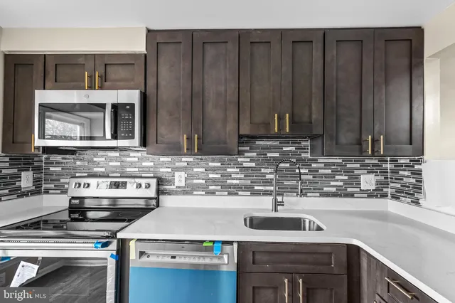 a kitchen with stainless steel appliances a stove and a sink