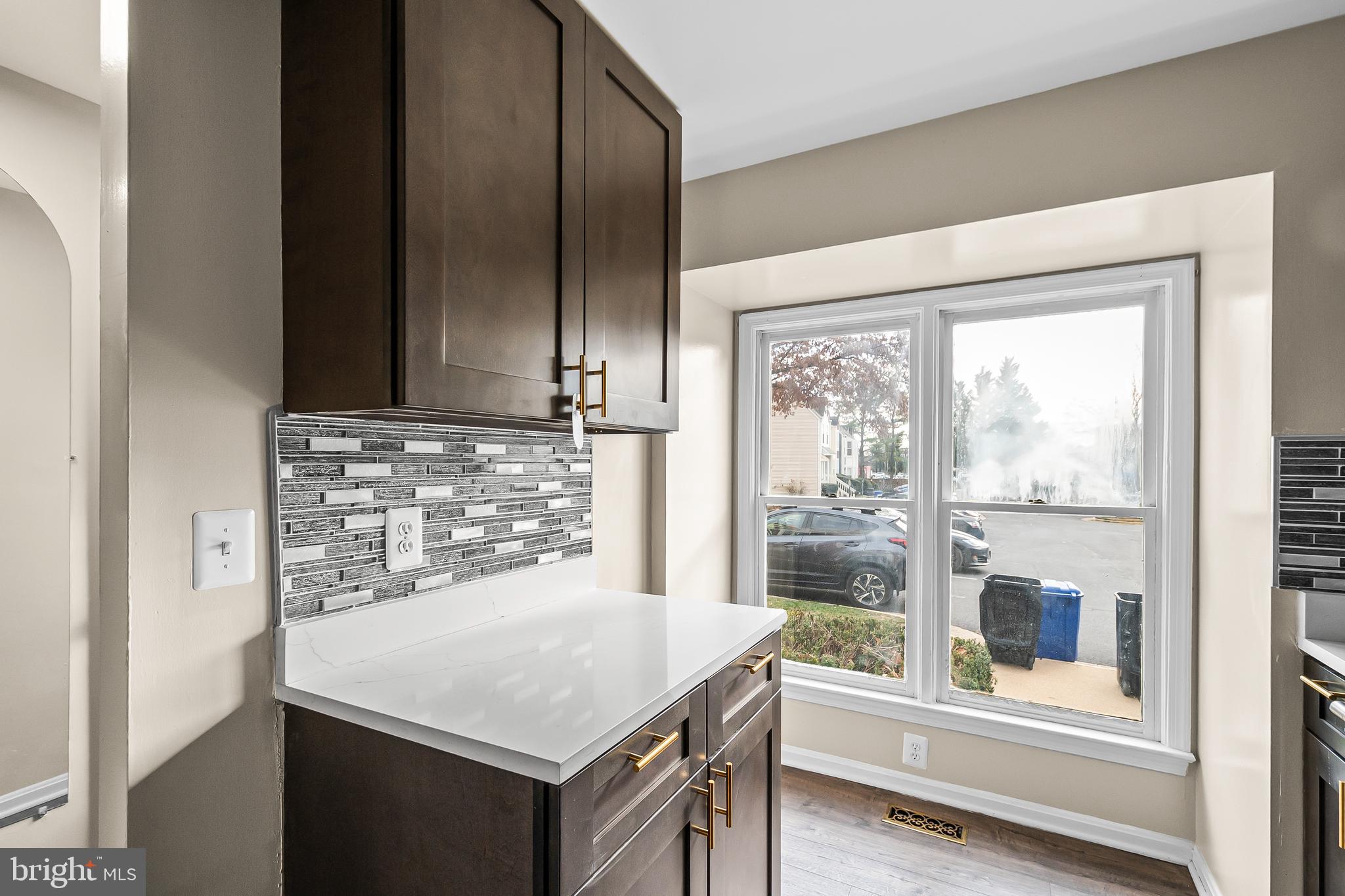 6185 Little Valley Way Alexandria, VA 22310 - Photo 9 of 44 a kitchen with a table a refrigerator and wooden floor
