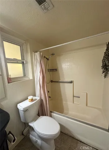 a white toilet sitting next to a bath tub