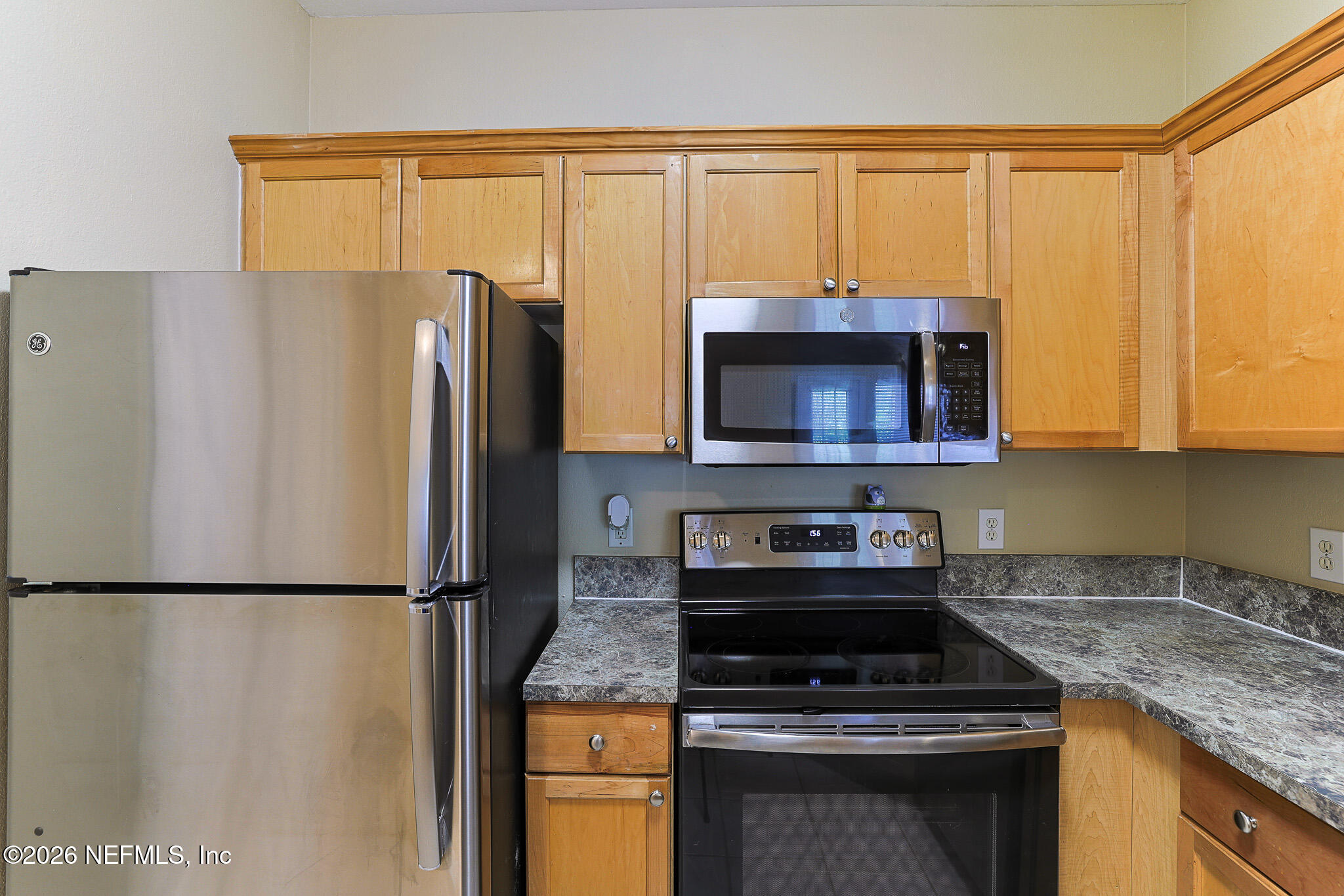 10961 Burnt Mill Road, Unit 426 Jacksonville, FL 32256 - Photo 5 of 24 a kitchen with stainless steel appliances granite countertop a stove a refrigerator and a microwave
