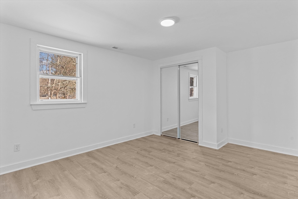 260 Great Road Stow, MA 01775 - Photo 25 of 32 a view of an empty room with wooden floor and a window