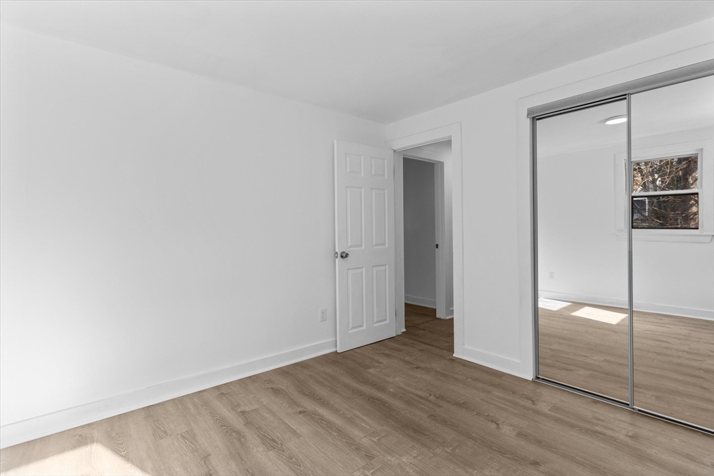 260 Great Road Stow, MA 01775 - Photo 30 of 32 an empty room with wooden floor and mirror