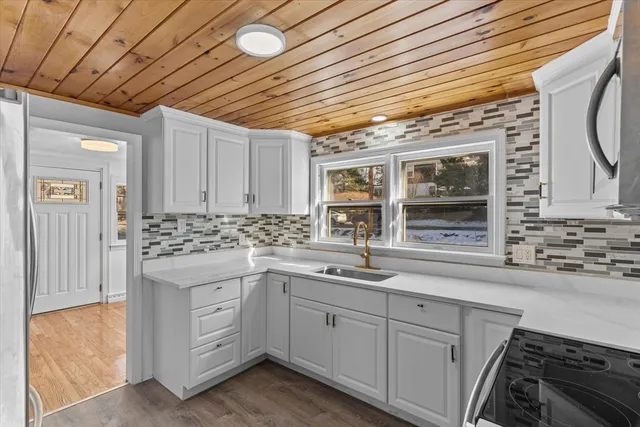 a kitchen with sink stove and cabinets