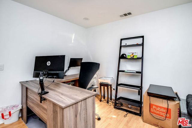 a view of a workspace with furniture and wooden floor