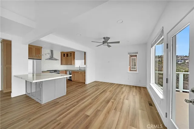 a large white kitchen with stainless steel appliances granite countertop a sink and dishwasher a stove top oven with wooden floor