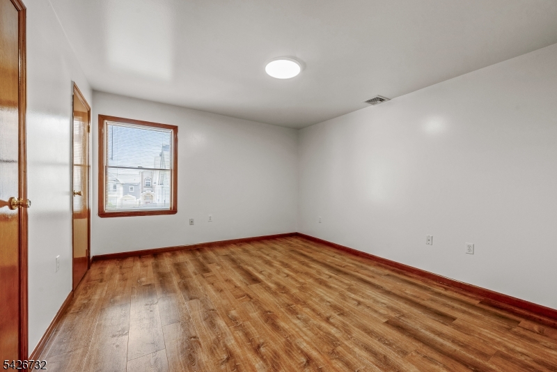 939 Grove Street Elizabeth, NJ 07202 - Photo 11 of 18 an empty room with wooden floor and windows