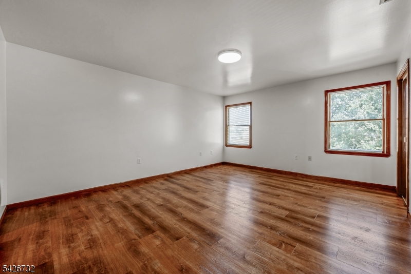 939 Grove Street Elizabeth, NJ 07202 - Photo 12 of 18 an empty room with wooden floor and windows