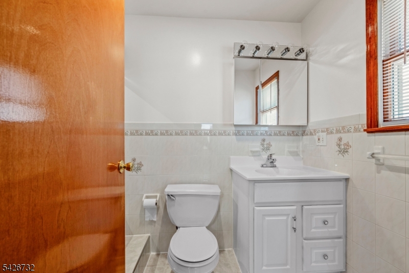 939 Grove Street Elizabeth, NJ 07202 - Photo 14 of 18 a bathroom with a toilet sink and mirror