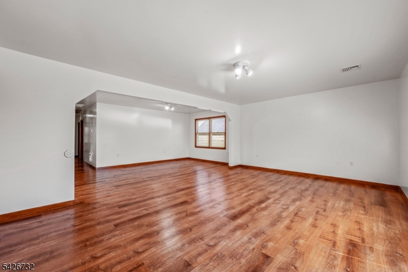 939 Grove Street Elizabeth, NJ 07202 - Photo 3 of 18 an empty room with wooden floor and windows
