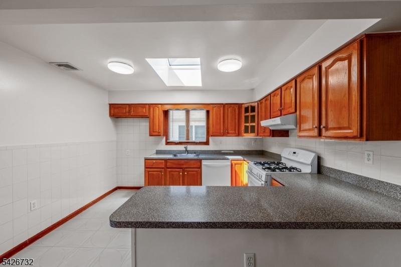 939 Grove Street Elizabeth, NJ 07202 - Photo 7 of 18 a kitchen with stainless steel appliances granite countertop a sink window and cabinets