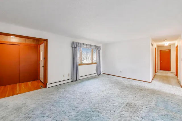 an empty room with windows and closet