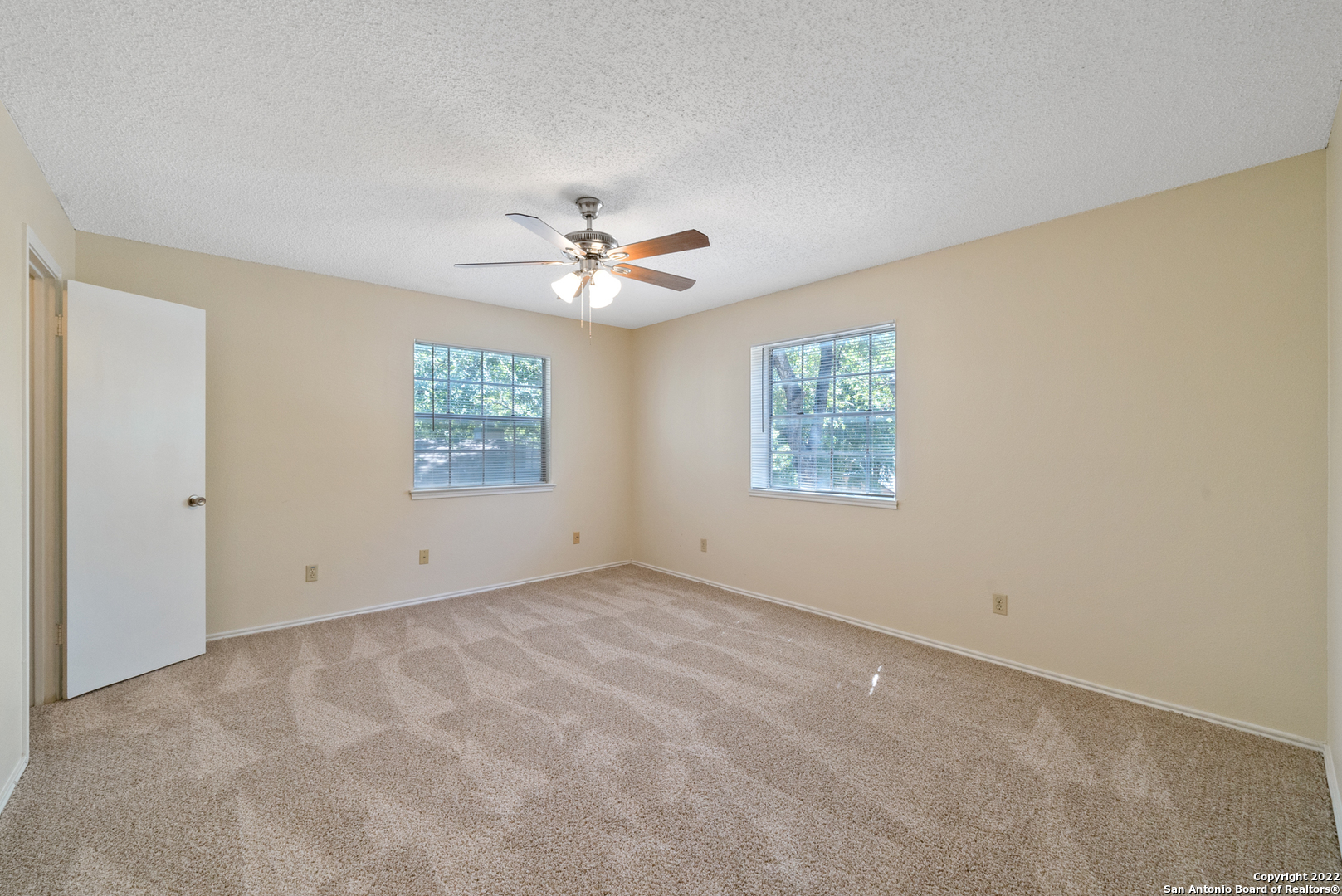 6122 Ridge Oak San Antonio, TX 78250 - Photo 18 of 31 an empty room with windows and ceiling fan