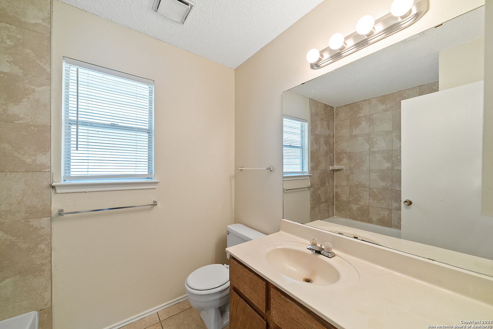6122 Ridge Oak San Antonio, TX 78250 - Photo 25 of 31 a bathroom with a sink toilet and vanity