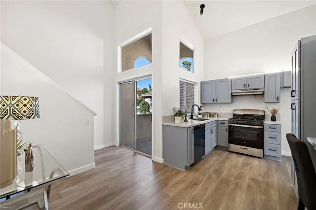 a kitchen with stainless steel appliances granite countertop a refrigerator a stove top oven a sink and dishwasher