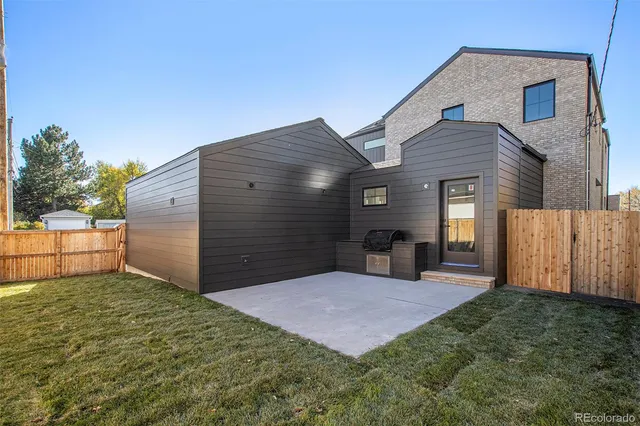 a view of a house with backyard and a tree