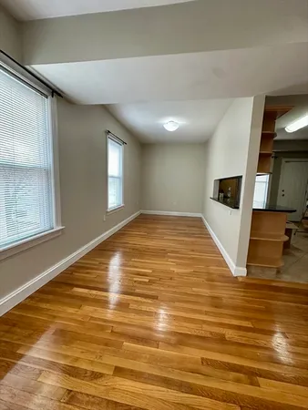 a view of a livingroom with wooden floor and kitchen