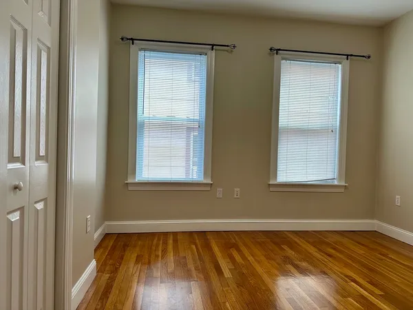 a view of a room with wooden floor and windows