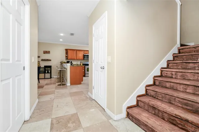 a view of a hallway with wooden floor and a kitchen