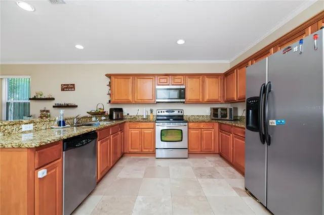 a large kitchen with stainless steel appliances granite countertop a stove sink and refrigerator