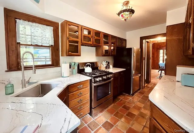 a kitchen with stainless steel appliances granite countertop a sink stove and refrigerator