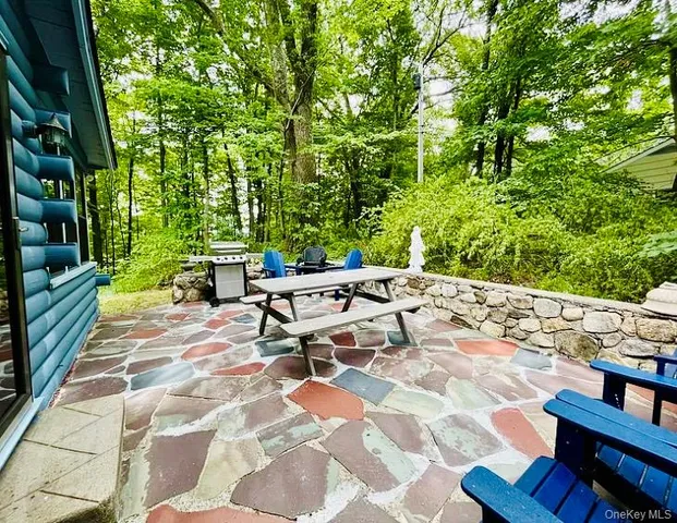 a view of a patio with table and chairs potted plants with wooden floor and fence