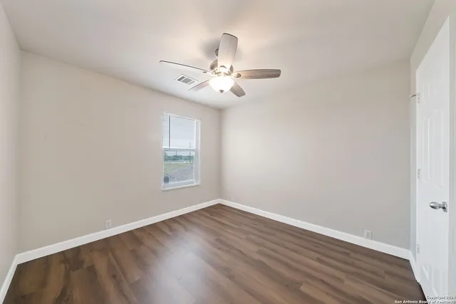 wooden floor in an empty room with a window