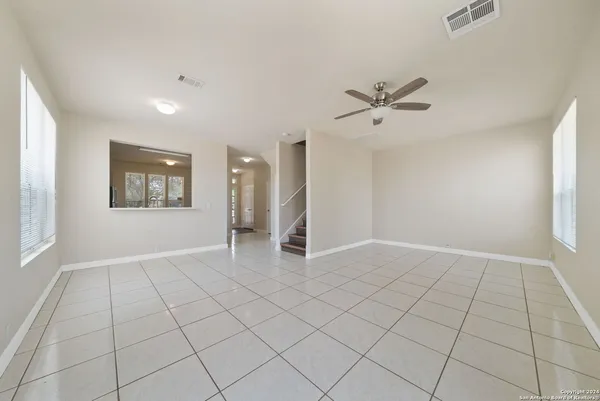 an empty room with windows and fan