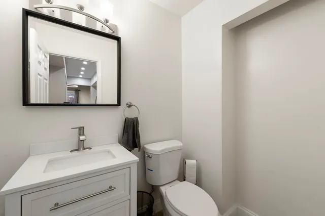 a bathroom with a toilet a sink and mirror