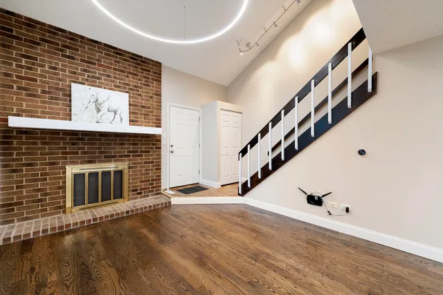 a view of a livingroom with wooden floor and staircase