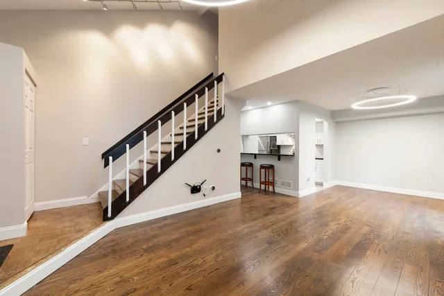 a view of empty room with wooden floor and stairs