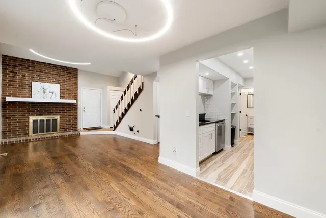 a view of a livingroom with wooden floor and a fireplace